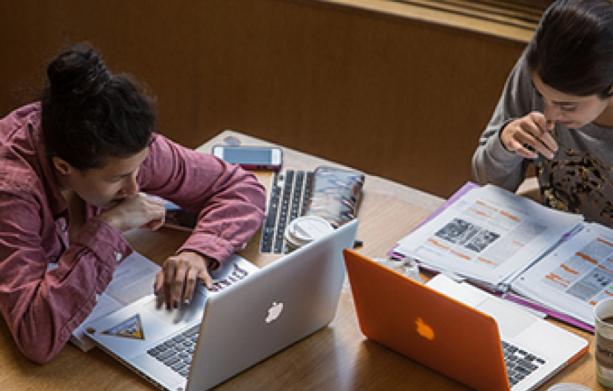 两个学生在图书馆用电脑工作